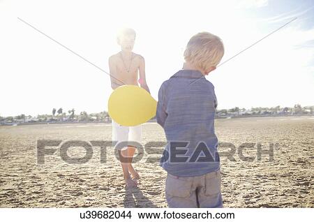 Male toddler and brother playing bat and ball on beach View Large Photo Image Picture - Male toddler and brother playing bat and ball on beach. Fotosearch