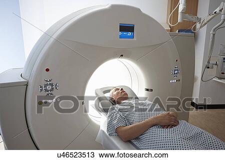 Stock Image - Man going into CT scanner. Fotosearch
