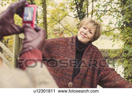 Man taking photo of woman on camera phone View Large Photo Image Stock Image - Man taking photo of woman on camera phone. Fotosearch