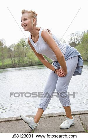 Stock Image - Mature woman exercising in park. Fotosearch