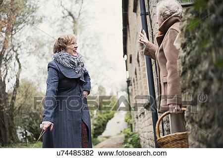 Stock Image - Mature woman greeting senior woman. Fotosearch