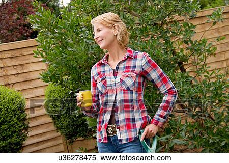 Mature woman having coffee break in garden View Large Photo Image Stock Photography - Mature woman having coffee break in garden. Fotosearch