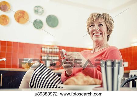 Mature woman holding cell phone in kitchen, portrait View Large Photo Image Stock Image - Mature woman holding cell phone in kitchen, portrait. Fotosearch