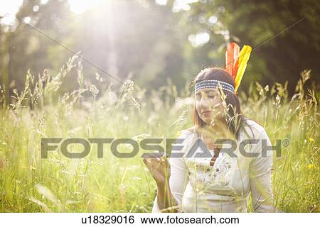 Mature woman in native american headdress in long grass View Large Photo Image Stock Photograph - Mature woman in native american headdress in long grass. Fotosearch