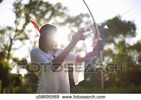 Mature woman in woodlands aiming bow and arrow View Large Photo Image Stock Photo - Mature woman in woodlands aiming bow and arrow. Fotosearch