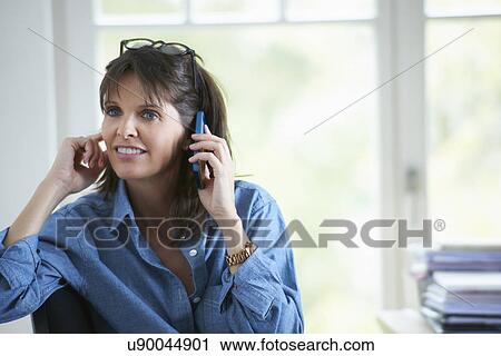 Stock Image - Mature woman on phonecall. Fotosearch