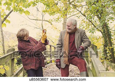 Stock Photo - Mature woman photographing senior man. Fotosearch