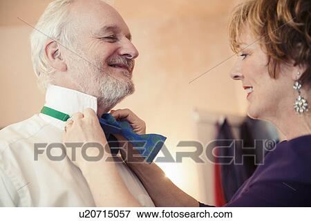 Mature woman putting bow tie on senior man View Large Photo Image Stock Photo - Mature woman putting bow tie on senior man. Fotosearch