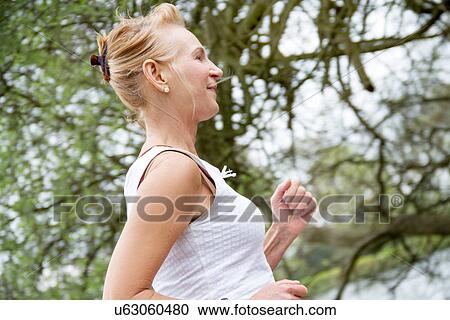 Mature woman running in park View Large Photo Image Stock Image - Mature woman running in park. Fotosearch