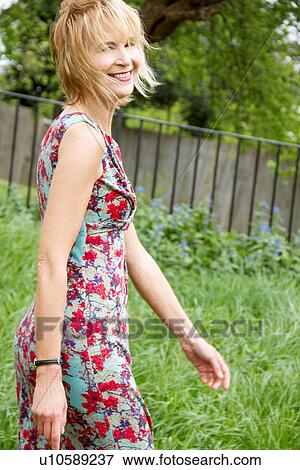 Mature woman walking through park View Large Photo Image Stock Photo - Mature woman walking through park. Fotosearch