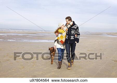 Mid adult couple and dog strolling on beach, Bloemendaal aan Zee, Netherlands View Large Photo Image Picture - Mid adult couple and dog strolling on beach, Bloemendaal aan Zee, Netherlands. Fotosearch