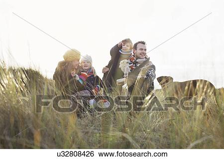 Mid adult couple in sand dunes with their son, daughter and dog View Large Photo Image Stock Photograph - Mid adult couple in sand dunes with their son, daughter and dog. Fotosearch
