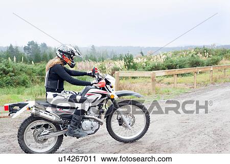 Mid adult female motorcyclist riding on dirt track View Large Photo Image Stock Image - Mid adult female motorcyclist riding on dirt track. Fotosearch