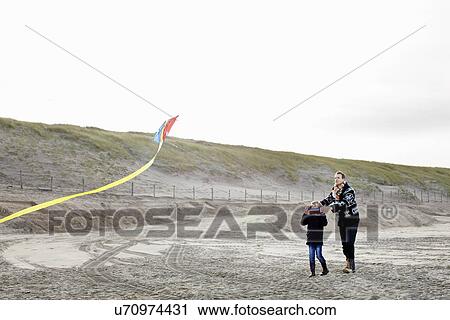 Mid adult man and son flying kite on beach, Bloemendaal aan Zee, Netherlands View Large Photo Image Stock Image - Mid adult man and son flying kite on beach, Bloemendaal aan Zee, Netherlands. Fotosearch