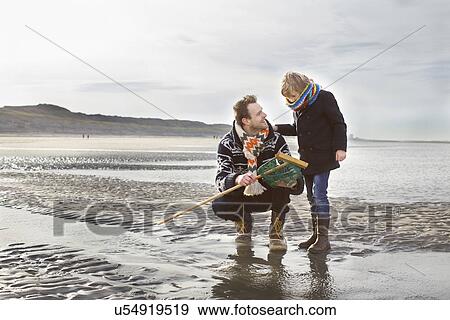 Mid adult man and son with fishing net on beach, Bloemendaal aan Zee, Netherlands View Large Photo Image Stock Photo - Mid adult man and son with fishing net on beach, Bloemendaal aan Zee, Netherlands. Fotosearch