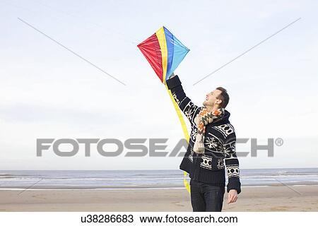 Mid adult man holding up kite on beach, Bloemendaal aan Zee, Netherlands View Large Photo Image Stock Image - Mid adult man holding up kite on beach, Bloemendaal aan Zee, Netherlands. Fotosearch
