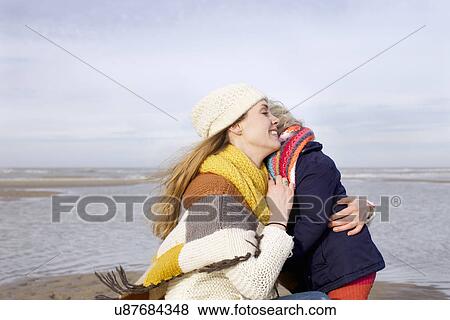 Mid adult woman hugging daughter on beach, Bloemendaal aan Zee, Netherlands View Large Photo Image Stock Photo - Mid adult woman hugging daughter on beach, Bloemendaal aan Zee, Netherlands. Fotosearch