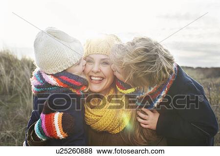 Mid adult woman with son and daughter kissing her cheek at coast View Large Photo Image Stock Photo - Mid adult woman with son and daughter kissing her cheek at coast. Fotosearch