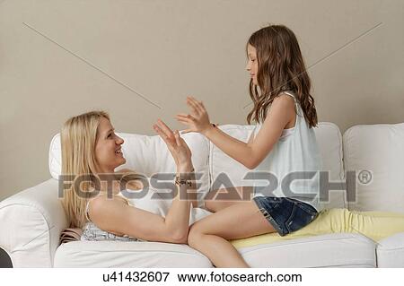Mother and daughter playing hand claps on sofa View Large Photo Image Stock Photo - Mother and daughter playing hand claps on sofa. Fotosearch