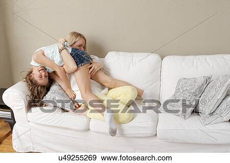 Stock Photo - Mother and daughter playing on sofa. Fotosearch