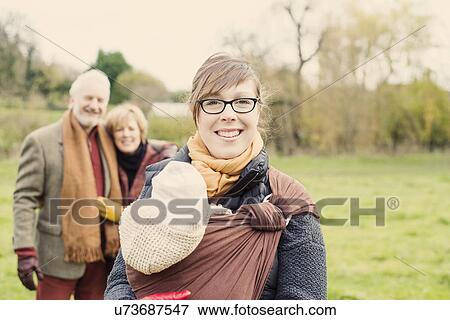 Mother carrying baby son, grandparents in background View Large Photo Image Stock Photo - Mother carrying baby son, grandparents in background. Fotosearch