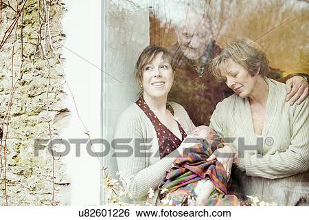 Mother with baby and grandparents looking out of window View Large Photo Image Stock Photograph - Mother with baby and grandparents looking out of window. Fotosearch