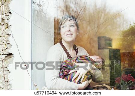 Mother with baby looking out of window View Large Photo Image Picture - Mother with baby looking out of window. Fotosearch