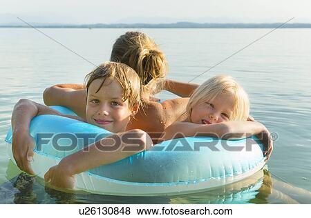 Mother with daughter and son in inflatable ring, Lake Starnberg, Bavaria, Germany View Large Photo Image Stock Photo - Mother with daughter and son in inflatable ring, Lake Starnberg, Bavaria, Germany. Fotosearch