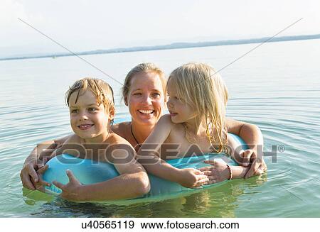 Stock Photo - Mother with daughter and son in inflatable ring, Lake Starnberg, Bavaria, Germany. Fotosearch