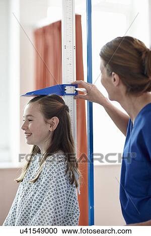 Nurse checking girl's height View Large Photo Image Stock Image - Nurse checking girl's height. Fotosearch