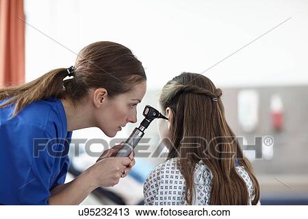 Nurse using otoscope on girl View Large Photo Image Stock Image - Nurse using otoscope on girl. Fotosearch