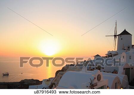 Stock Image - Oia town and windmill at sunset, Santorini, Cyclades Islands, Greece. Fotosearch
