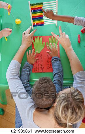 Overhead view of teacher and pupils with abacus at nursery school View Large Photo Image Stock Image - Overhead view of teacher and pupils with abacus at nursery school. Fotosearch