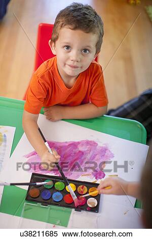 Portrait of boy painting at nursery school View Large Photo Image Stock Photography - Portrait of boy painting at nursery school. Fotosearch