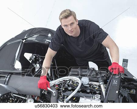 Stock Image - Portrait of engineer assembling supercar in sports car factory. Fotosearch