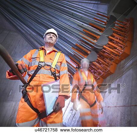 Stock Photo - Portrait of engineers in front of cable anchorage in suspension bridge. The Humber Bridge, UK, built in 1981 was the world's largest single-span suspension bridge. Fotosearch