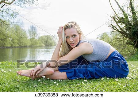 Portrait of flexible young woman exercising near lake View Large Photo Image Stock Photo - Portrait of flexible young woman exercising near lake. Fotosearch
