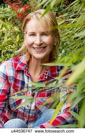 Stock Photo - Portrait of mature woman in garden. Fotosearch
