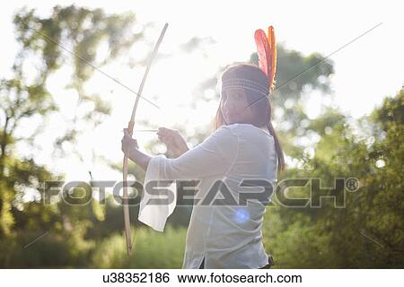 Portrait of mature woman in woodlands aiming bow and arrow View Large Photo Image Stock Photograph - Portrait of mature woman in woodlands aiming bow and arrow. Fotosearch