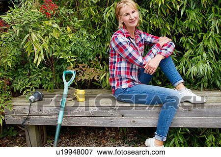 Portrait of mature woman taking a break on garden seat View Large Photo Image Stock Photo - Portrait of mature woman taking a break on garden seat. Fotosearch