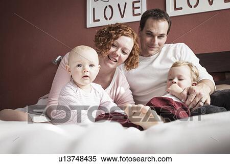 Portrait of mid adult couple with son and baby daughter on bed View Large Photo Image Stock Photography - Portrait of mid adult couple with son and baby daughter on bed. Fotosearch