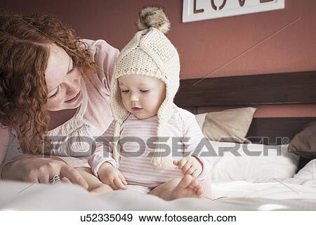 Portrait of mid adult mother and baby girl in knitted hat View Large Photo Image Stock Photo - Portrait of mid adult mother and baby girl in knitted hat. Fotosearch