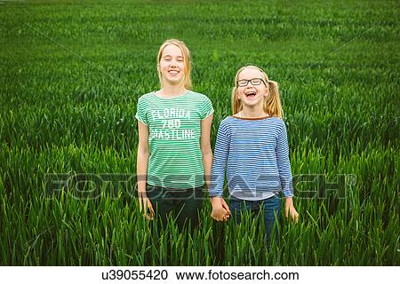 Portrait of nine year old girl and sister holding hands in field View Large Photo Image Stock Image - Portrait of nine year old girl and sister holding hands in field. Fotosearch