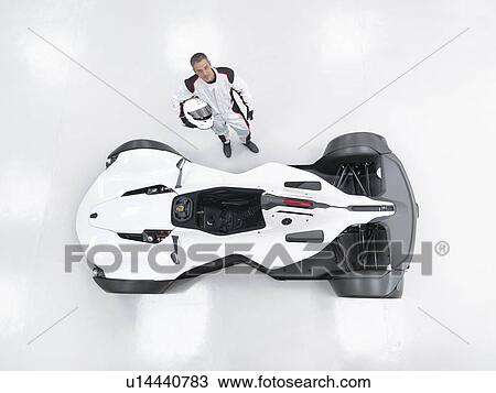 Stock Image - Portrait of racing driver next to supercar, overhead view. Fotosearch