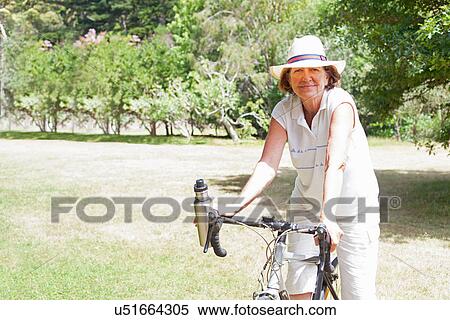 Portrait of senior woman cyclist in park View Large Photo Image Stock Photography - Portrait of senior woman cyclist in park. Fotosearch