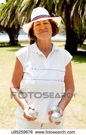 Portrait of senior woman with boule balls in park View Large Photo Image Stock Photo - Portrait of senior woman with boule balls in park. Fotosearch