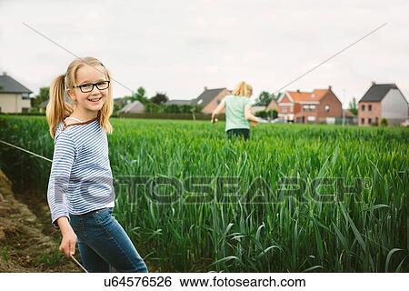 Portrait of sisters in field, one running and one posing View Large Photo Image Stock Photograph - Portrait of sisters in field, one running and one posing. Fotosearch