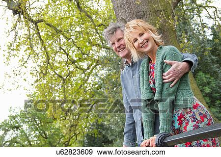 Stock Photo - Portrait of smiling adult couple in park. Fotosearch