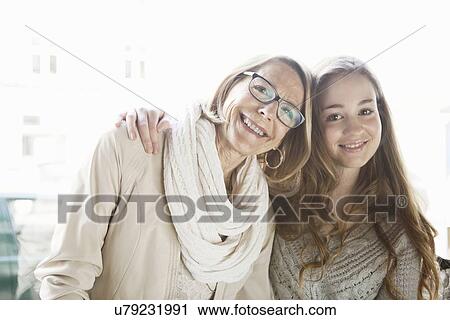 Stock Image - Portrait of teenage girl and grandmother in cafe window seat. Fotosearch