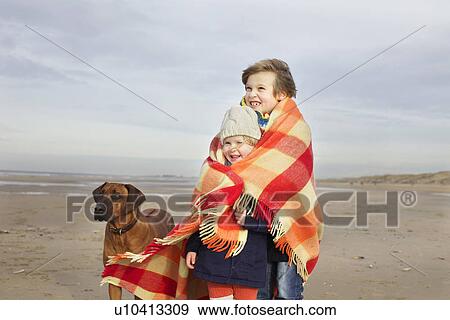 Portrait of three year old girl and brother wrapped in blanket on beach, Bloemendaal aan Zee, Netherlands View Large Photo Image Stock Photo - Portrait of three year old girl and brother wrapped in blanket on beach, Bloemendaal aan Zee, Netherlands. Fotosearch